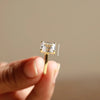four prong setting beside emerald cut diamond ring.